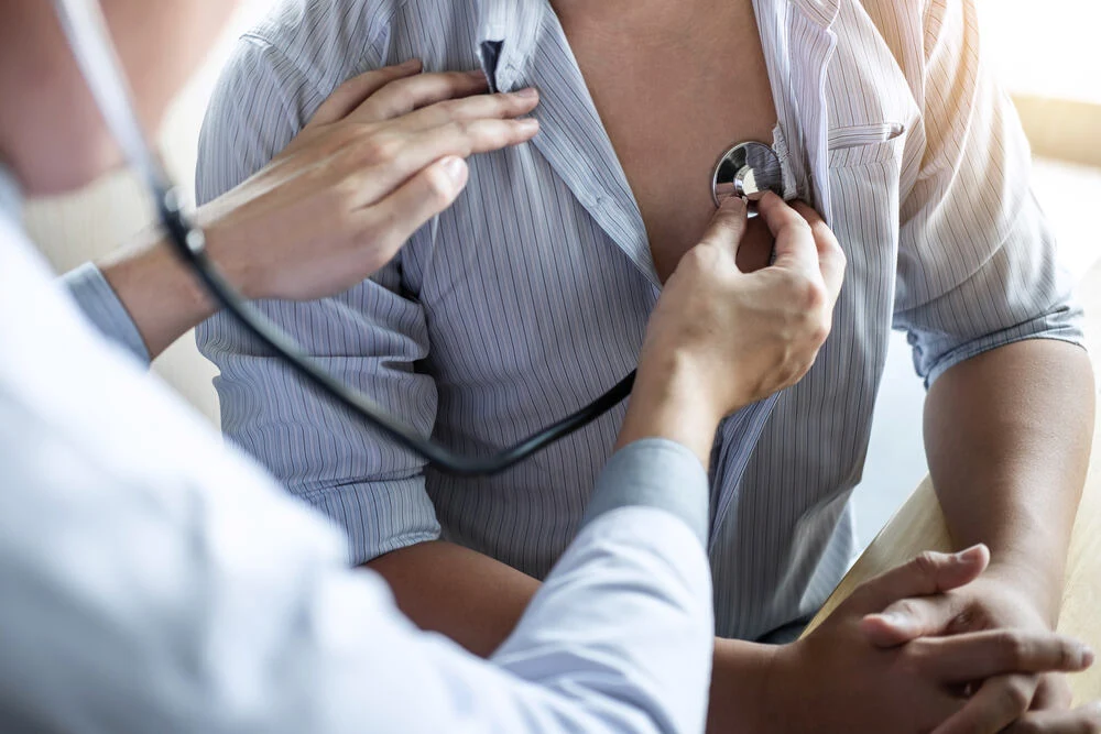 Doctor using a stethoscope checking patient with examining