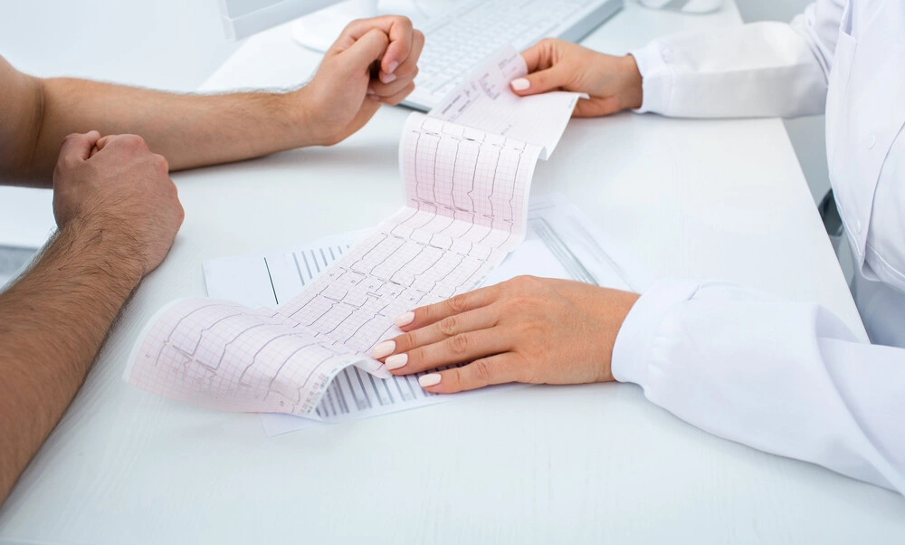 Doctor analyzes the electrocardiogram results, close-up
