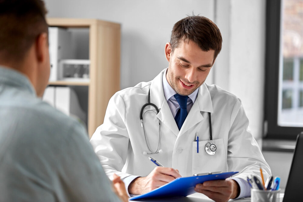 Doctor talking to a patient while holding a clipboard