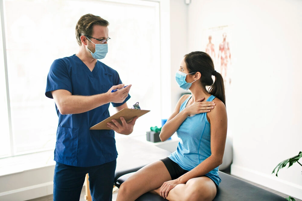 A Male Physical Therapist Stretching a Female Patient Slowly.