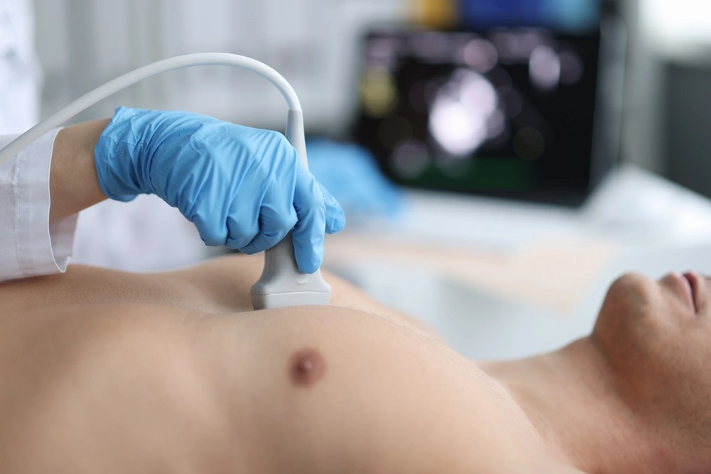 Doctor performs chest ultrasound on man in hospital closeup